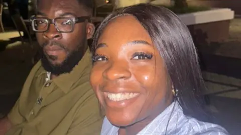 Christopher Nwangene Ifunanya Nwangene smiles in a night-time selfie with her brother Kingsley as they sit at a tale outside