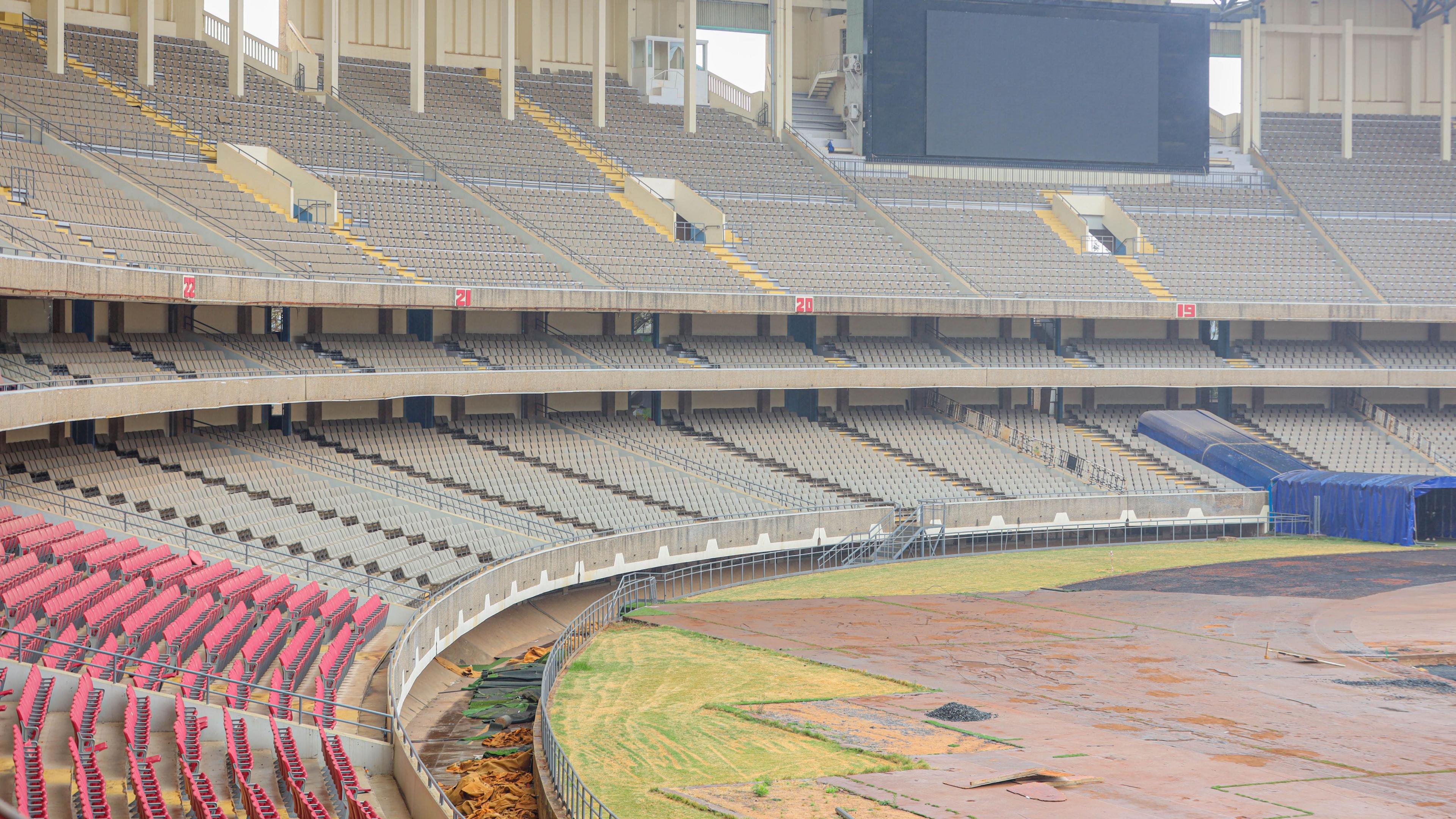 The Kasarani Stadium under renovation, showing a vast three-tier stand with only one section of seating and a bare field